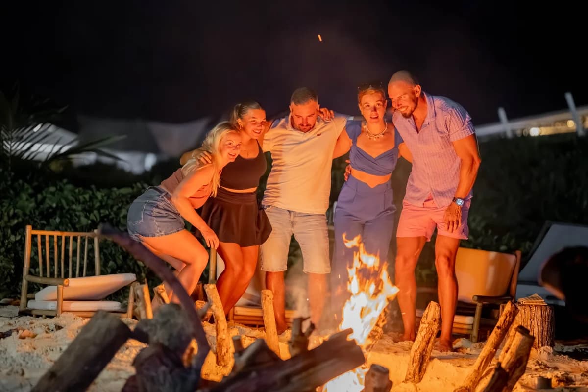 Guests gathered around a beach bonfire at Vahmaafushi